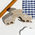 Détail de la pince à cheveux en résine crème latte avec motifs de cœurs et de nœuds - Style d'Arche Khaki
