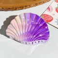 Macro shot of seashell hair claw with holographic gradient pink to purple metallic finish - Pink Purple