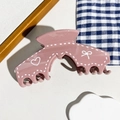 Détail d'une pince à cheveux rose crème avec motifs de cœurs et finition brillante - Style d'Arche Rose Poudré