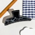 Détail d'une pince à cheveux noire brillante avec motifs de cœurs et lignes ECG - Style de Triangle Oblique Noir