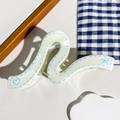 Détail de la pince à cheveux ondulée crème avec motifs cœur bleu, nœud et coutures - Style de Vague Géométrique Blanc Cassé