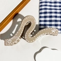 Détail d'une pince à cheveux vague crème avec motifs de cœur et de surpiqûres - Style de Vague Géométrique Khaki