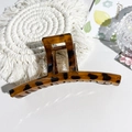 Dettaglio di una grande pinza per capelli leopardata su sfondo bianco strutturato - 13cm Dritto-Leopardo Caffè Lucido