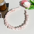 Close-up of light pink pleated satin headband placed on a minimalist desktop with flowers - Ruched Satin Thin Headband / Pink