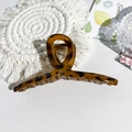 Macro shot of large leopard print hair claw clip with metal spring on a woven mat - 13cm Cross-Glossy Coffee Leopard
