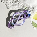 Dettaglio del fermaglio per capelli con motivo marmorizzato viola e design a nodo infinito - Blu e Viola