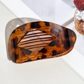 Detail of tortoiseshell leopard print hair claw clip showing internal teeth and curved structure - Glossy Tortoiseshell