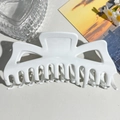 Top-down view of a large white matte shark hair claw clip styled on a lifestyle background - Large Monster (13.5cm) / White