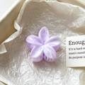 Gros plan sur la pince à cheveux fleur violette marbrée dans son coffret cadeau chic - Lavande