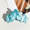Detailed macro view of three marbled blue plumeria acetate hair claws on white card - Lake Blue