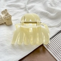Detailed macro view of cream resin shark hair claw clip with golden metal spring - UV Solid Creamy Yellow