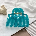 Detail showing the translucent teal large hair claw clip with its golden metal spring - UV Transparent Peacock Blue