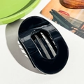 Detail view of large black oval hair claw clip with strong grip teeth on white background - Oval Clip / UV Solid Black
