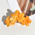 Détail d'une pince à cheveux fleur de frangipanier orange avec texture marbrée pour la plage - Orange