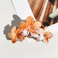 Vue détaillée de la pince à cheveux triple frangipanier avec texture marbrée orange en résine - Orange Coloré