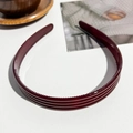 Dettaglio del cerchietto antiscivolo rosso vino scuro con denti interni su sfondo testurizzato - Cerchietto Largo In PC A Righe / Rosso Vino Lucido