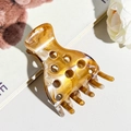 Detailed view of an amber marble acetate hair claw clip on a stylish white background - Khaki