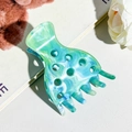 Detailed macro shot of marbled teal hair claw clip with cutout holes and fixing teeth - Emerald Green