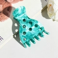 Detailed view of large marble texture green hair claw clip with cutout design on leather - Lake Green
