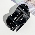 Close-up of heart-shaped black hair claw clip with white polka dots on leather background - Black Heart Polka Dot (9.5cm)