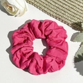 Detailed close-up of a magenta ribbed knit scrunchie on a white textured leather surface - Rose Red