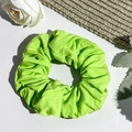 Close-up of fluorescent green oversized scrunchie with ribbed texture and soft knit fabric - Grass Green