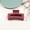 Pince à cheveux carrée bordeaux mat avec design ajouré sur un fond d'accessoires de mode - Rouge Vin Mat
