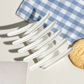 Close-up of white matte multi-tooth hair claw clip on a stylish textured background - Matte White