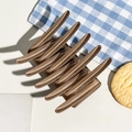 Macro detail of large matte bronze hair claw clip with strong metal spring mechanism - Matte Milk Coffee