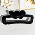 Detail of a large black hollow rectangular hair claw clip with double heart accents - Black