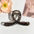 Detail view of a translucent smoke grey shark hair clip with a sleek matte finish - 10cm Cross Style / Transparent Dark Gray