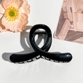 Detail view of glossy black twisted hair claw clip on elegant white leather background - 10cm Cross Style / Glossy Black