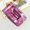 Detail of pink marble hair claw clip with hollow stripe design on breakfast table - Pink Purple