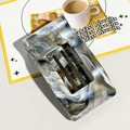 Close-up of marble pattern rectangular hair claw clip on a stylish breakfast table - Coffee & Black