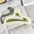 Detailed macro view of the cream-colored matte resin hair claw clip with non-slip teeth - Milk Yellow