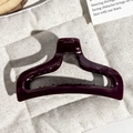 Top view of a deep purple glossy fishtail hair claw clip on beige linen fabric - Fuschia