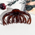 Dettaglio macro della molletta per capelli in resina ambrata lucida per capelli lunghi - Ambra trasparente