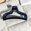Detail of large navy blue marble hair claw clip with geometric hollow design on soft fabric - Transparent Navy Blue