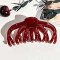 Dettaglio macro della molletta per capelli rosso ciliegia in resina lucida per capelli folti - Rosso Vino Trasparente