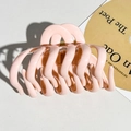 Detail of soft pink large pumpkin hair claw clip showing glossy finish and gold spring - Pink