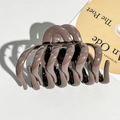 Detail of mocha brown resin hair claw clip with golden metal spring and wavy tooth design - Brown
