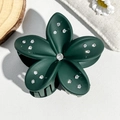 Detail view of a 8cm dark green flower hair claw clip with rhinestones on a wooden base - Matte Dark Green
