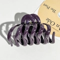 Macro shot of large purple silicone pumpkin hair claw clip showing gold metal spring - Dark Purple