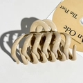 Macro shot of large beige pumpkin claw clip with wave pattern and polished resin finish - Milk Coffee