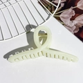 Detailed close-up of cream cross claw clip with golden metal spring on textured background - Milk Yellow
