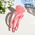 Detailed macro view of pink marble patterned resin hair comb with five smooth prongs - Pink