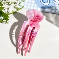 Detailed macro of pink marble acetate octopus hair claw clip with glossy textured finish - Pink Purple