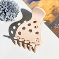 Detailopname van beige matte acryl haarklem met een patroon van holle stippen erop - Mat Lichtroze