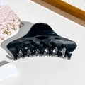 Dettaglio di una grande molletta per capelli nera lucida con molla in metallo resistente - Nero Lucido