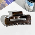Detailed view of the dark brown marble resin hair claw clip with its sleek rectangular shape - PC / Dark Brown